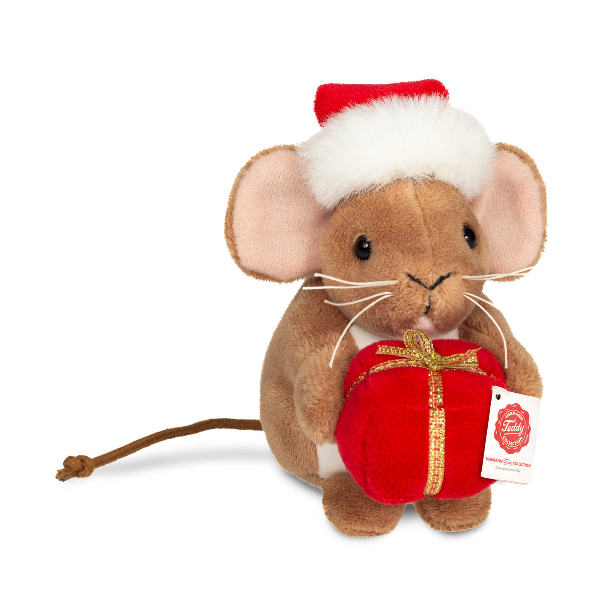 Det här är en liten julmus från Teddy-Hermann. Den sitter upprätt och håller i en röd present med guldband. Pälsen är brun, kort och slät med svag glans, magen är vit och öronens insida rosa. Ögonen är svarta och runda, nosen liten, svart och triangelformad, morrhåren vita och långa. Öronen är stora och rundade, tassarna bruna och en lång, tunn svans sticker ut bakom. Den har en röd tomteluva med vit, fluffig kant och pompom, och uttrycket verkar milt och glatt.