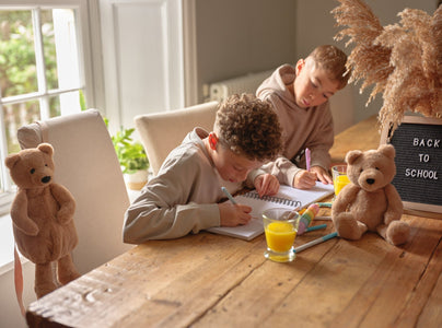 Children doing homework with Charlie Bear and the bear backpack