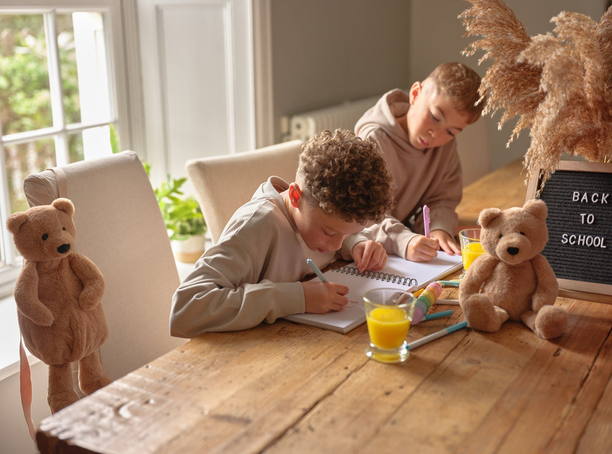 Children doing homework with Charlie Bear and the bear backpack