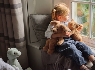 Child at the window with Ruff Puppy and Charlie Bear