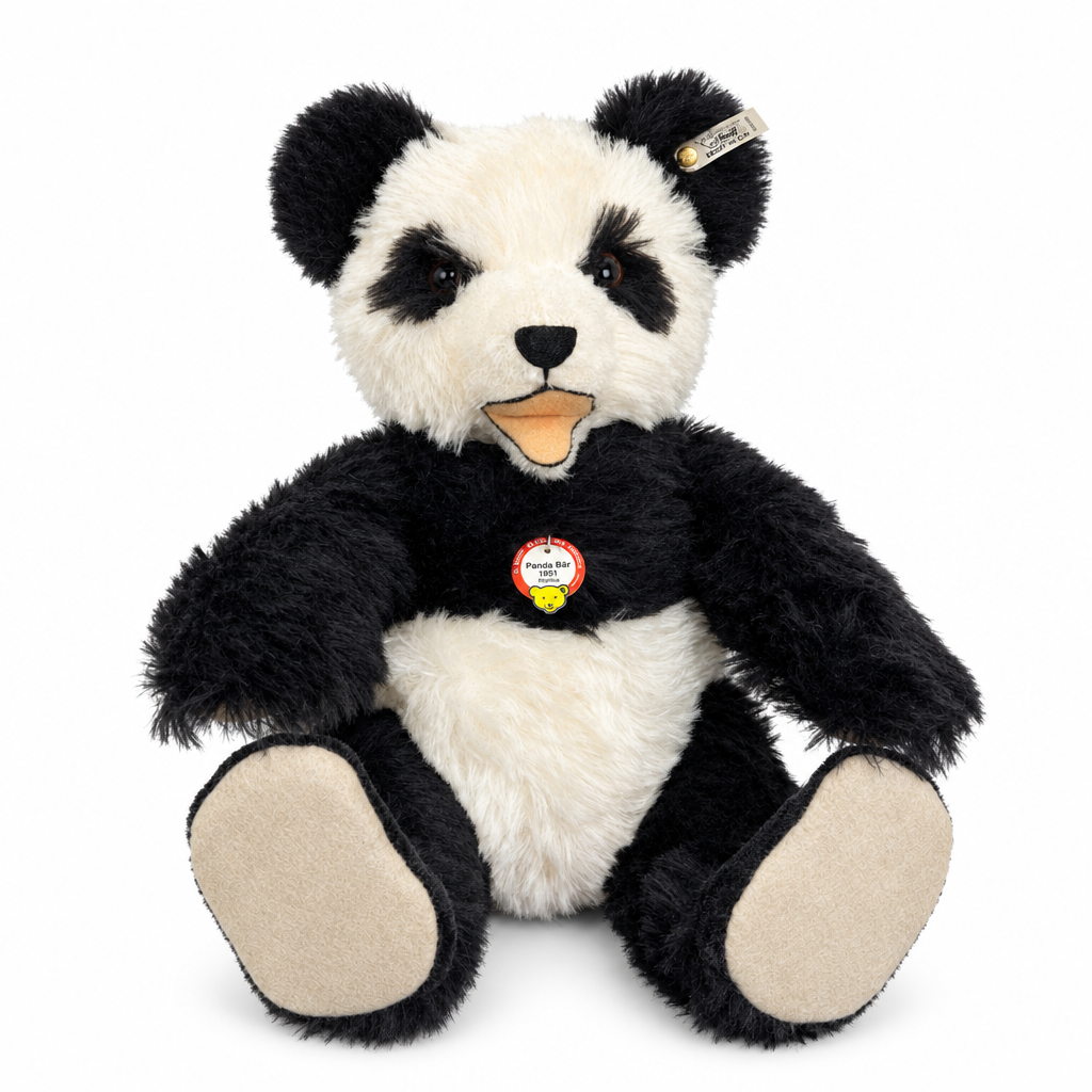 Det här är en panda från Steiff. Stor panda med lurvig, halvlång päls som verkar tät och något glansig. Svart på öron, ögonfläckar, armar, ben och axlar, vitt mitt i ansiktet, på magen och bröstet; trampdynor och synliga fotsulor är beige. Nospartiet är vitt med en liten svart trekantig nos och en kort svart lodrät söm nedanför. Ögonen är mörkbruna och sitter i de svarta fläckarna. Munnen är öppen med beige-orange tunga och beige insida. Pandan sitter och har en mild, lätt förvånad min.