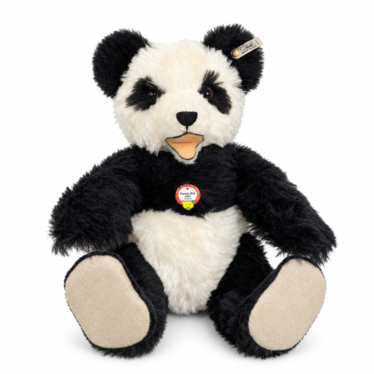 Det här är en panda från Steiff. Stor panda med lurvig, halvlång päls som verkar tät och något glansig. Svart på öron, ögonfläckar, armar, ben och axlar, vitt mitt i ansiktet, på magen och bröstet; trampdynor och synliga fotsulor är beige. Nospartiet är vitt med en liten svart trekantig nos och en kort svart lodrät söm nedanför. Ögonen är mörkbruna och sitter i de svarta fläckarna. Munnen är öppen med beige-orange tunga och beige insida. Pandan sitter och har en mild, lätt förvånad min.